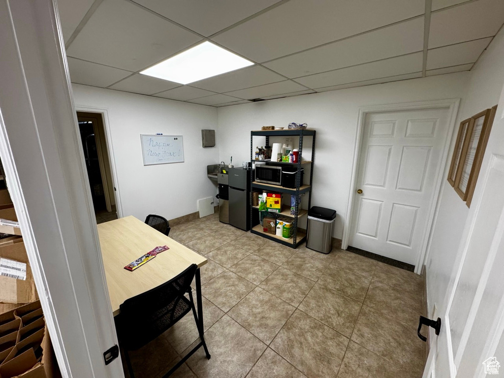 Office featuring a drop ceiling and light tile patterned floors