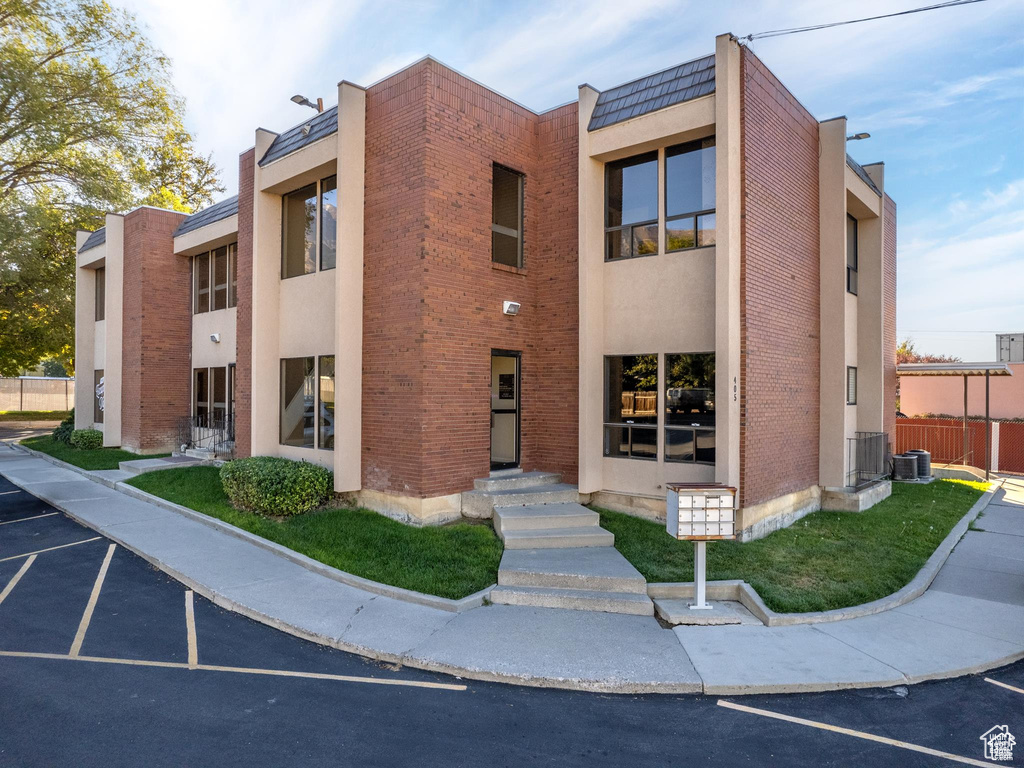 View of building exterior featuring uncovered parking