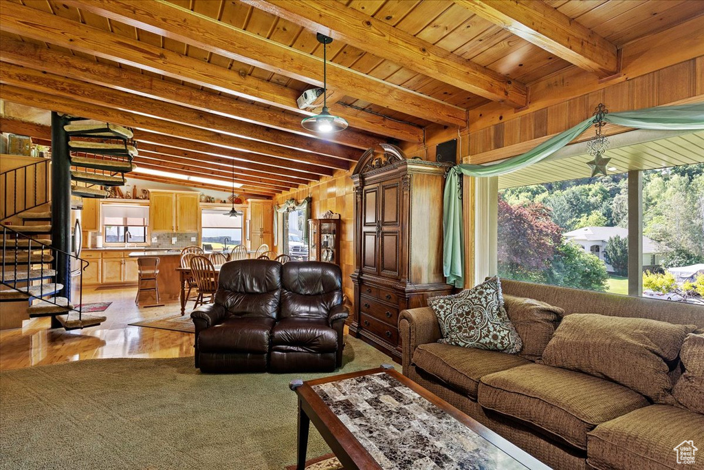 Living area featuring stairway and a wood ceiling with exposed beams