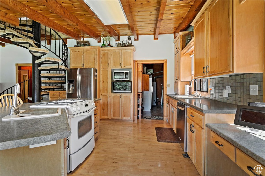 Kitchen with stainless steel appliances, a wood ceiling with exposed beams, light wood-style floors, tasteful backsplash, and dark countertops