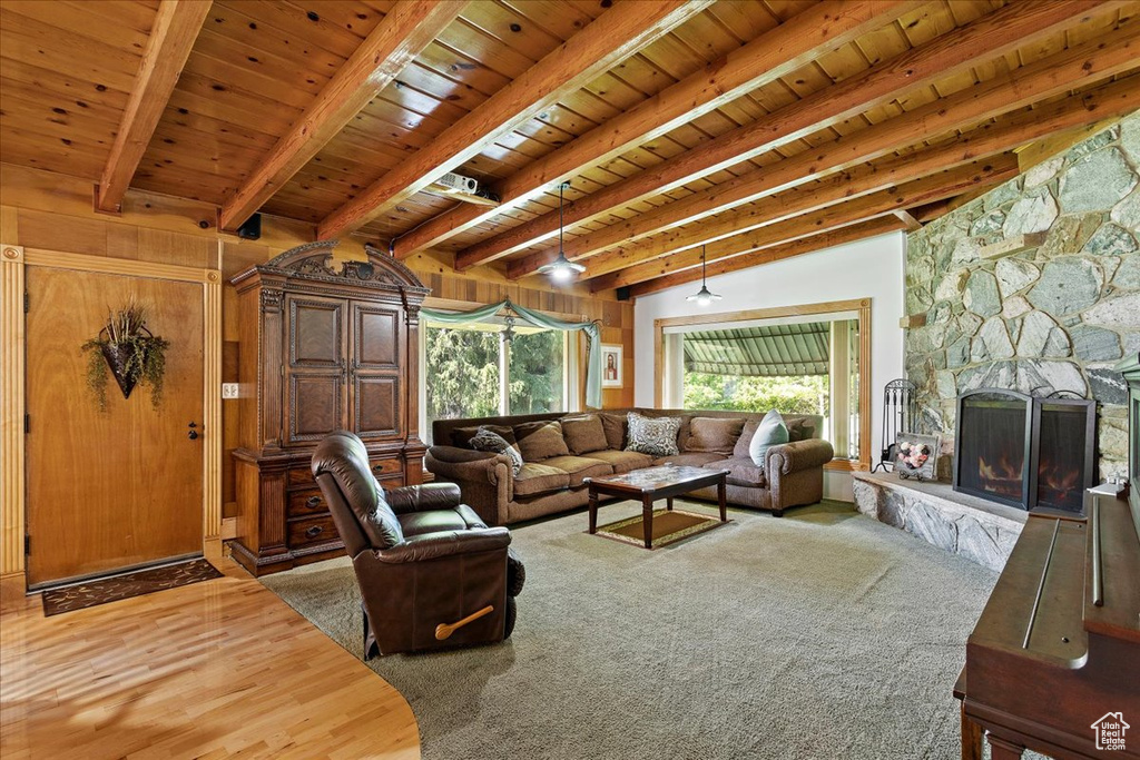 Living room featuring a wood ceiling with exposed beams, wood finished floors, and a fireplace