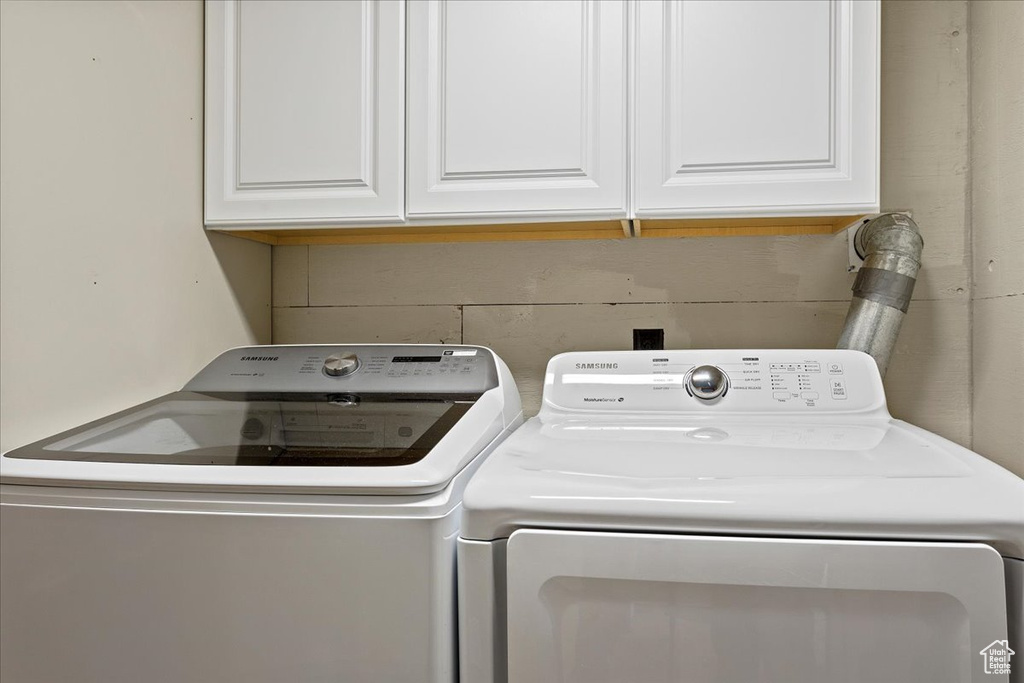 Washroom with cabinet space and washing machine and dryer