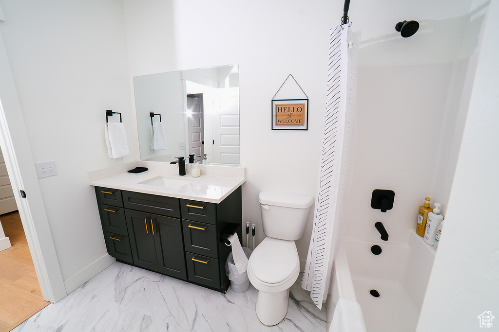 Bathroom featuring vanity, marble finish flooring, tub / shower combination, and a closet