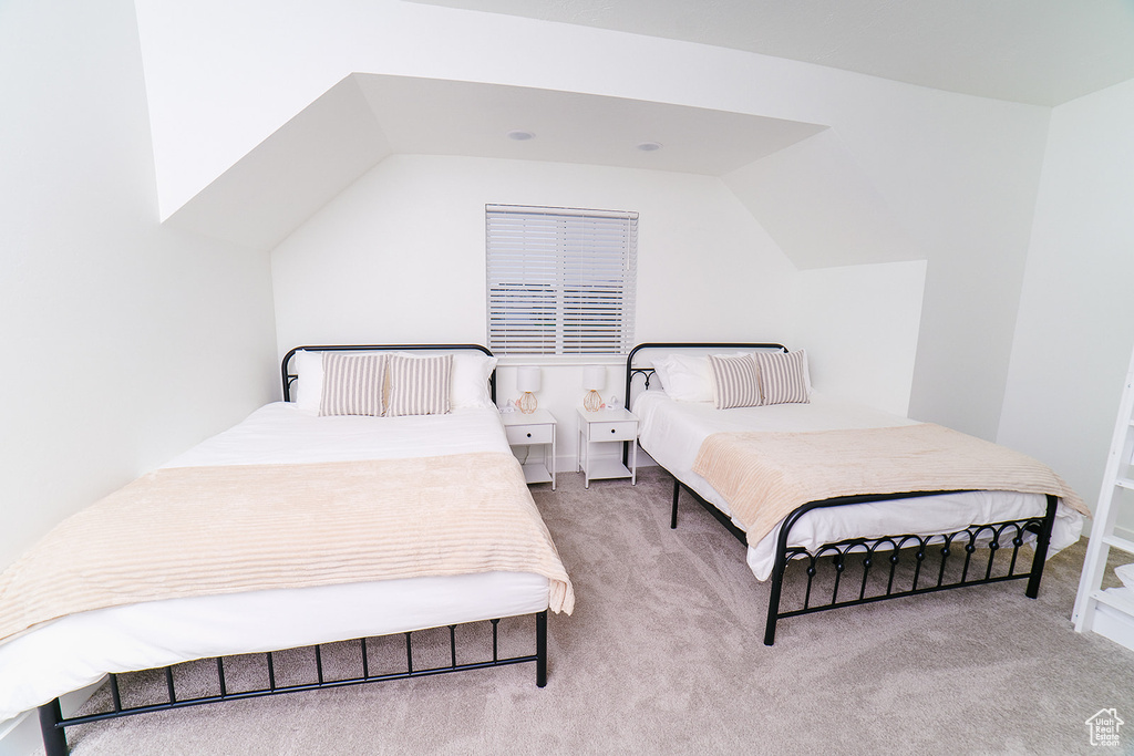 Bedroom featuring carpet flooring and lofted ceiling