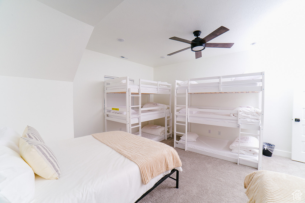 Carpeted bedroom with a ceiling fan and baseboards