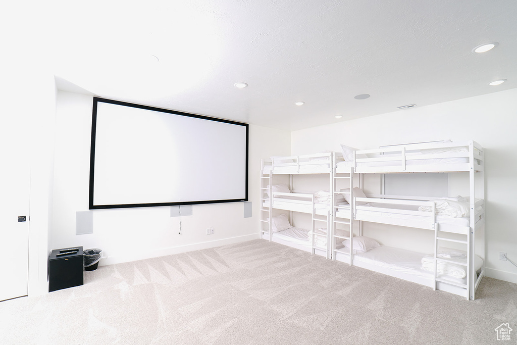 Carpeted home theater room featuring recessed lighting and baseboards