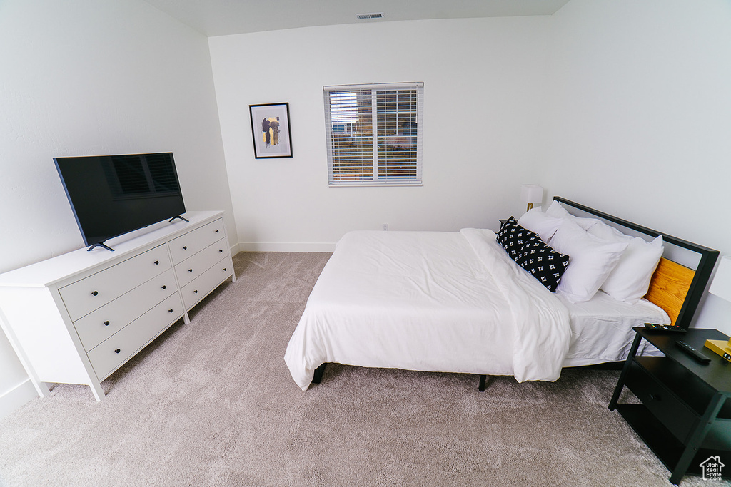Bedroom with light colored carpet and baseboards