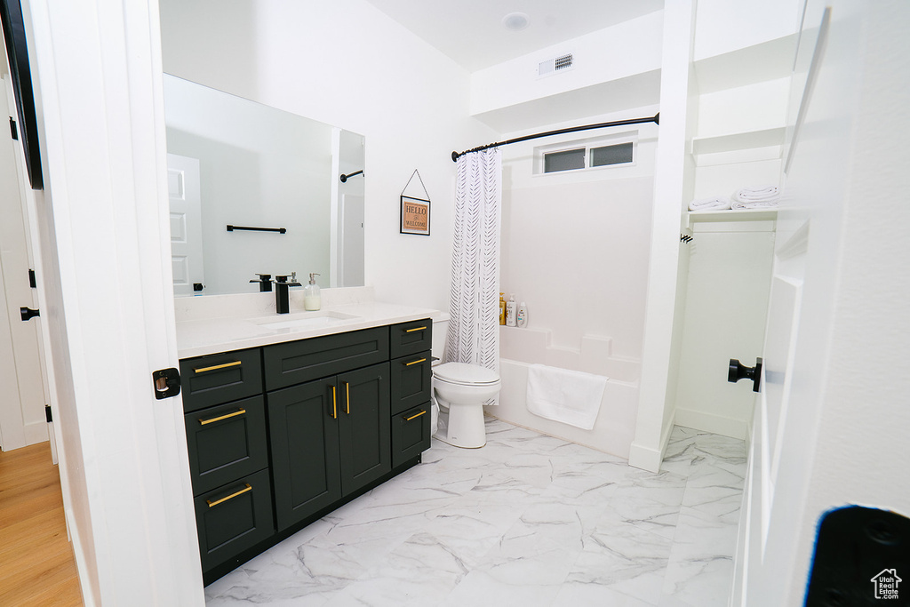 Bathroom with vanity, shower / bath combination with curtain, and marble finish floors