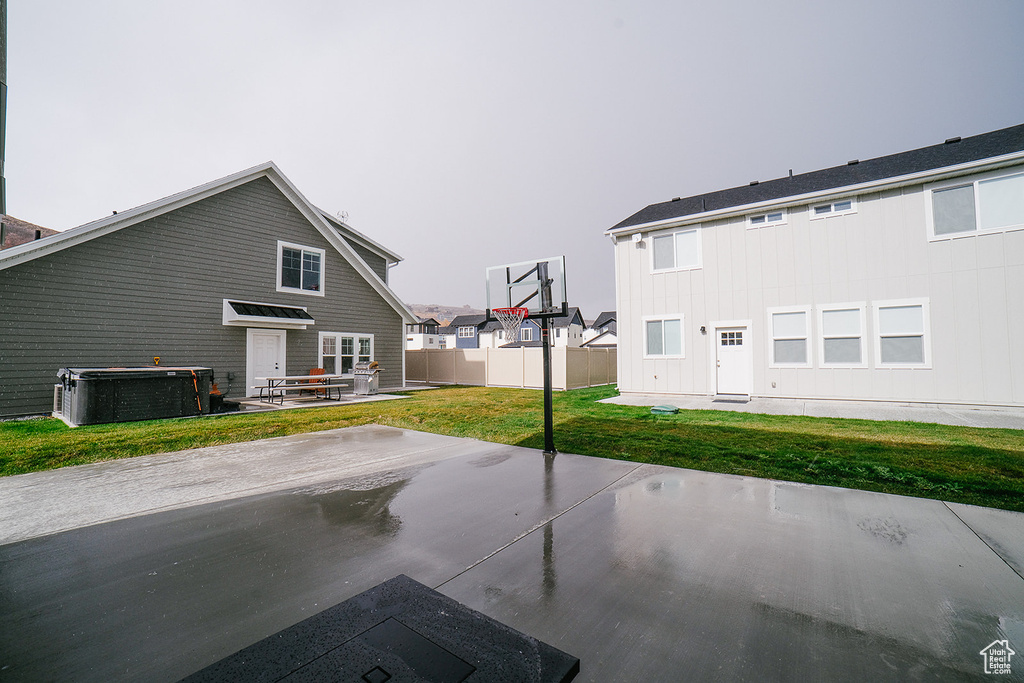 Back of house featuring a patio, a yard, and board and batten siding