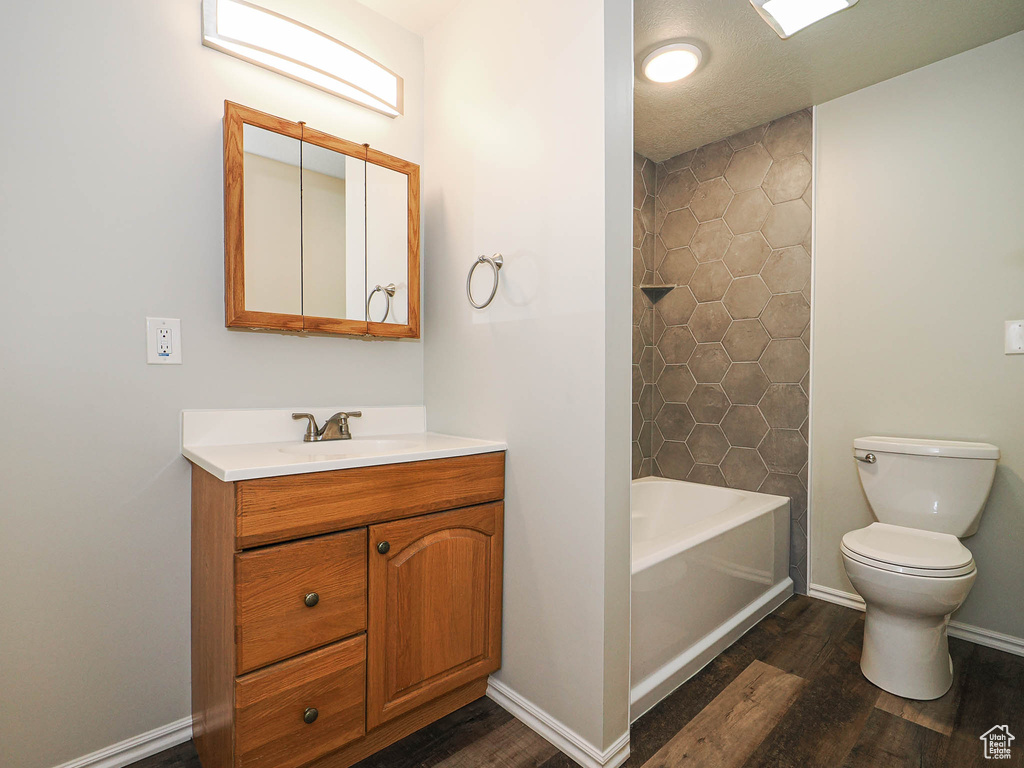 Full bath featuring wood finished floors, vanity, and shower / bath combination