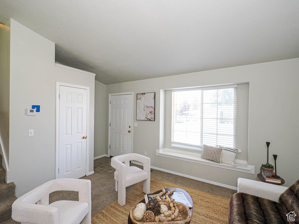Carpeted living room featuring baseboards and stairway