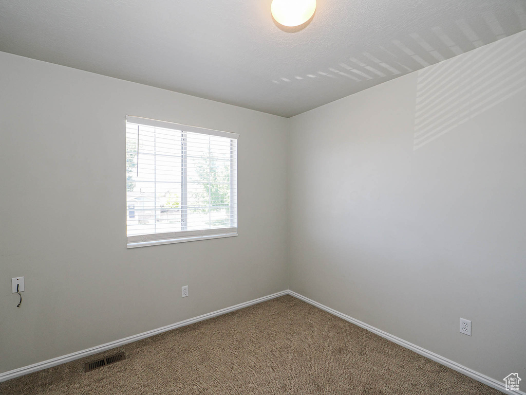 Unfurnished room featuring carpet floors and baseboards
