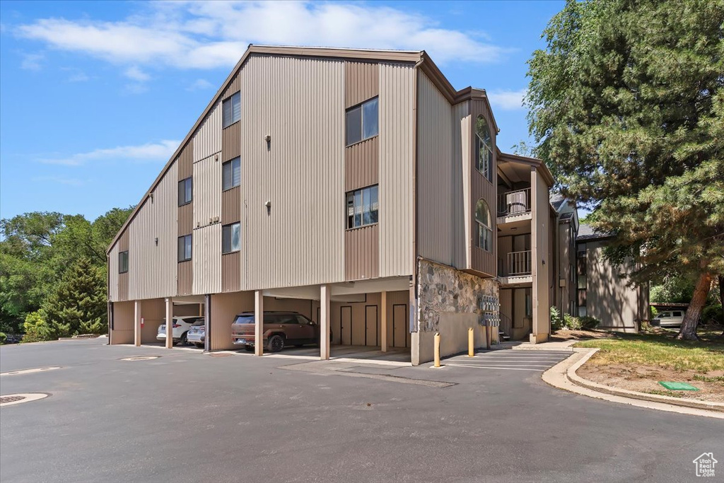 View of building exterior featuring covered parking