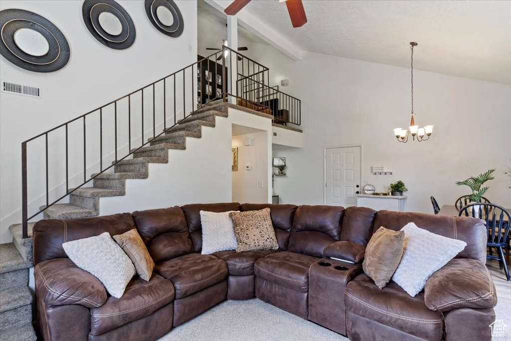 Living area featuring stairs, ceiling fan, a chandelier, high vaulted ceiling, and beamed ceiling