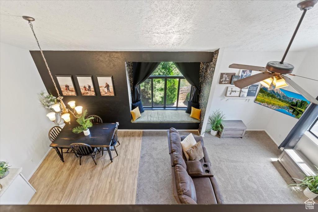 Living area with a textured ceiling, wood finished floors, and a ceiling fan