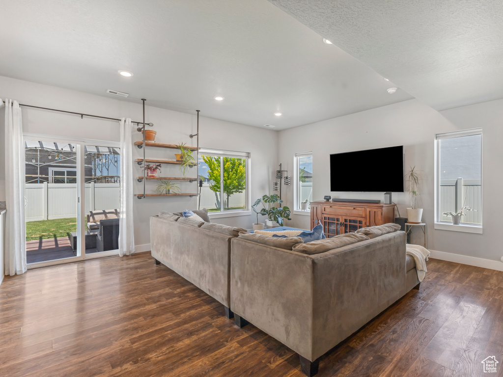Living area featuring dark wood-style flooring and recessed lighting