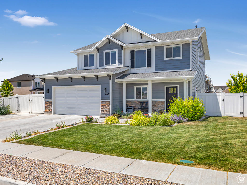 Craftsman inspired home with a gate, a porch, concrete driveway, and board and batten siding