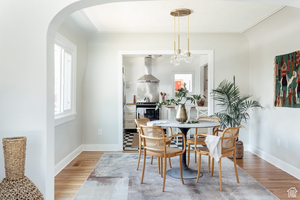 Dining area featuring wood finished floors and arched walkways