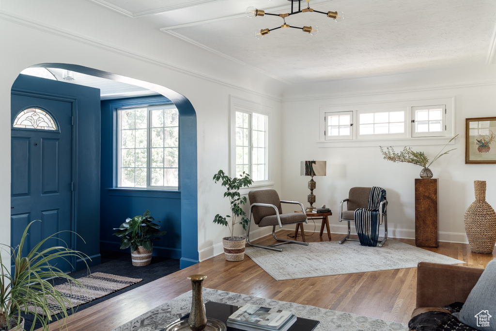 Living room featuring arched walkways, wood finished floors, and a chandelier