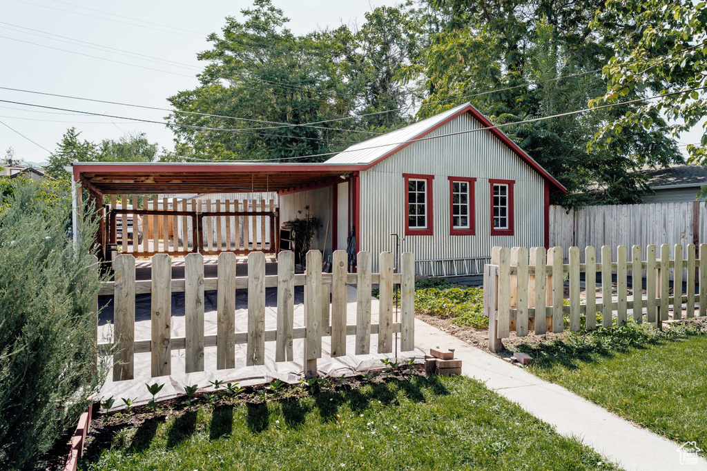 View of front of home with a carport and a fenced front yard