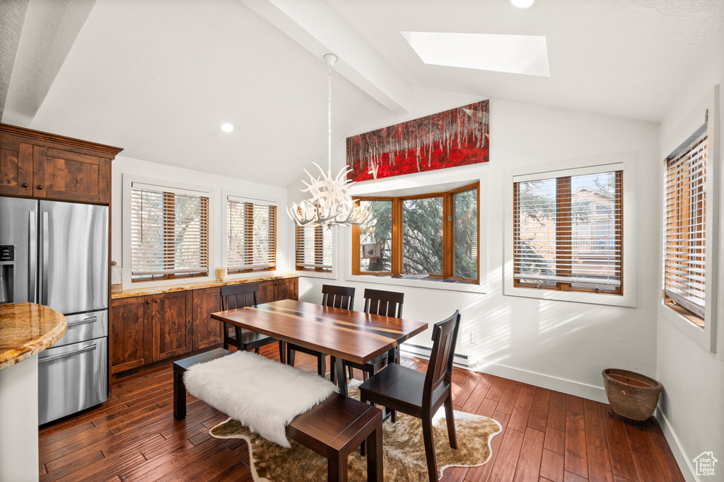 Dining space with a skylight, dark wood finished floors, a chandelier, and recessed lighting