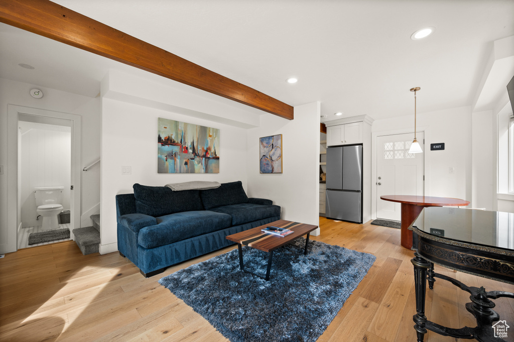 Living room featuring beamed ceiling, light wood-style floors, and recessed lighting