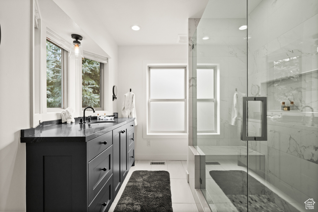 Full bathroom featuring vanity, a marble finish shower, and recessed lighting