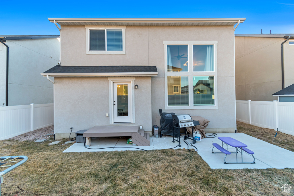 Back of property with a fenced backyard, stucco siding, and a patio area