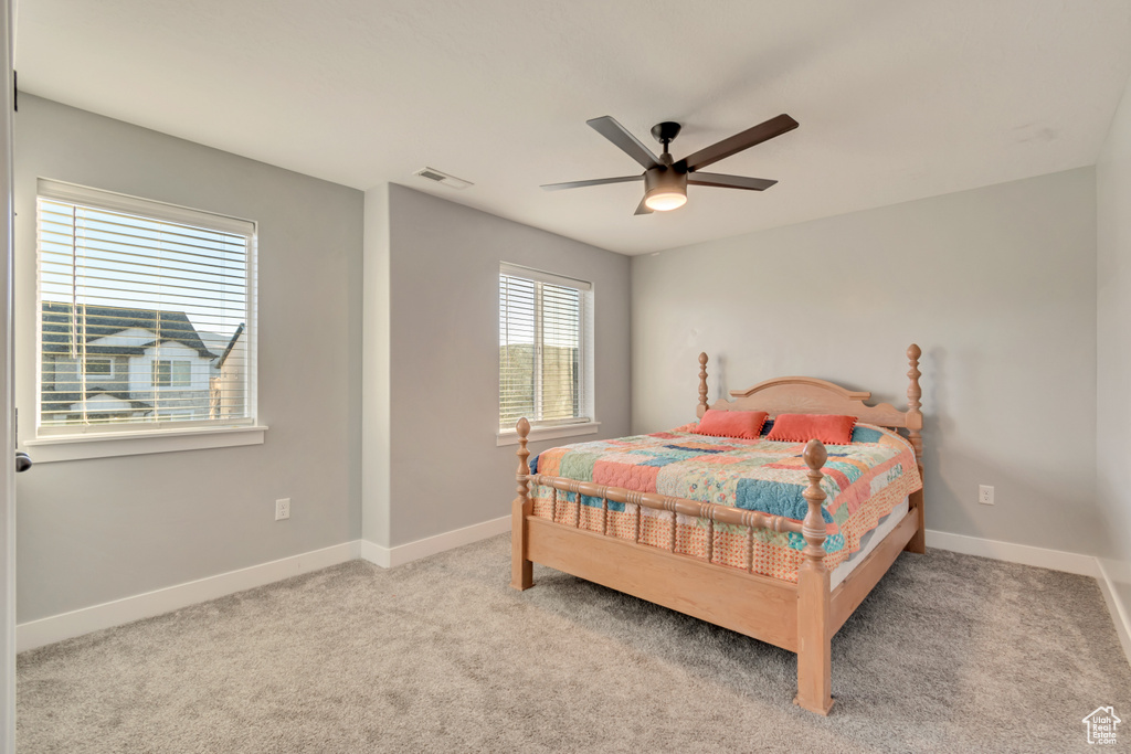 Carpeted bedroom featuring baseboards and ceiling fan