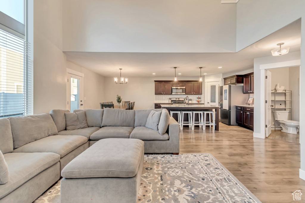 Living area with light wood-style flooring, a chandelier, and recessed lighting
