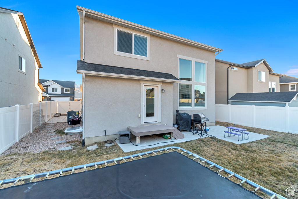 Rear view of property with stucco siding, a patio area, and a fenced backyard