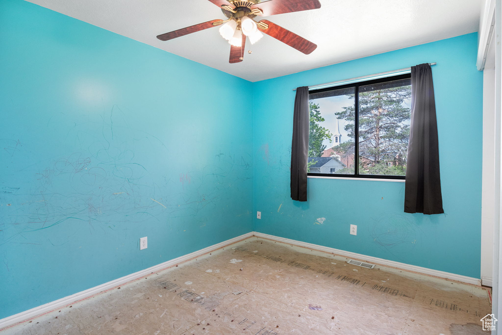 Empty room with baseboards and ceiling fan