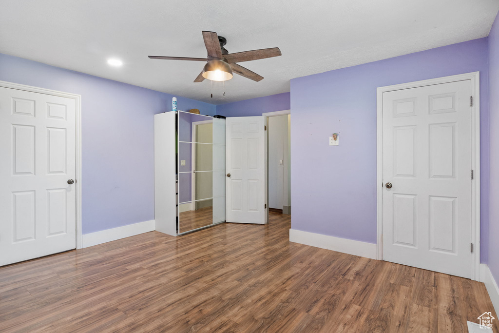 Unfurnished bedroom with wood finished floors, a ceiling fan, and recessed lighting