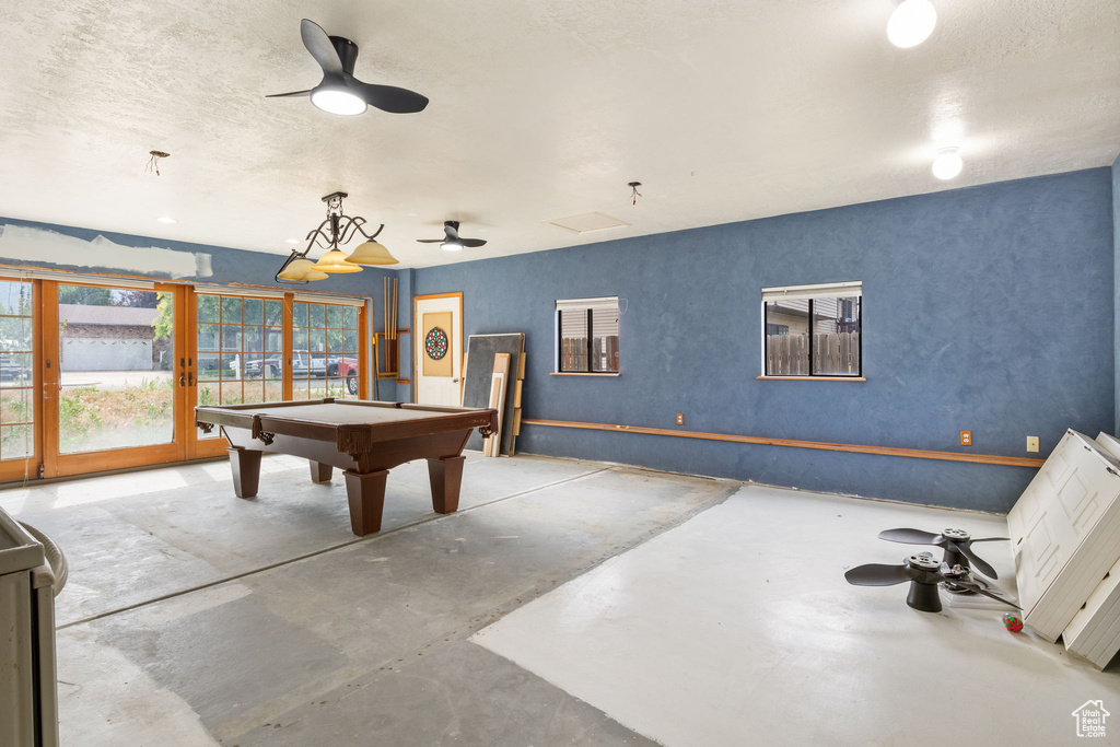 Recreation room with concrete flooring, a ceiling fan, billiards, and french doors