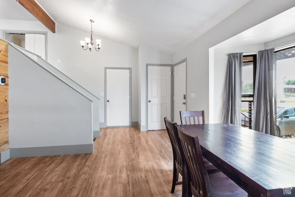 Dining area featuring a chandelier, light wood-style flooring, and stairway
