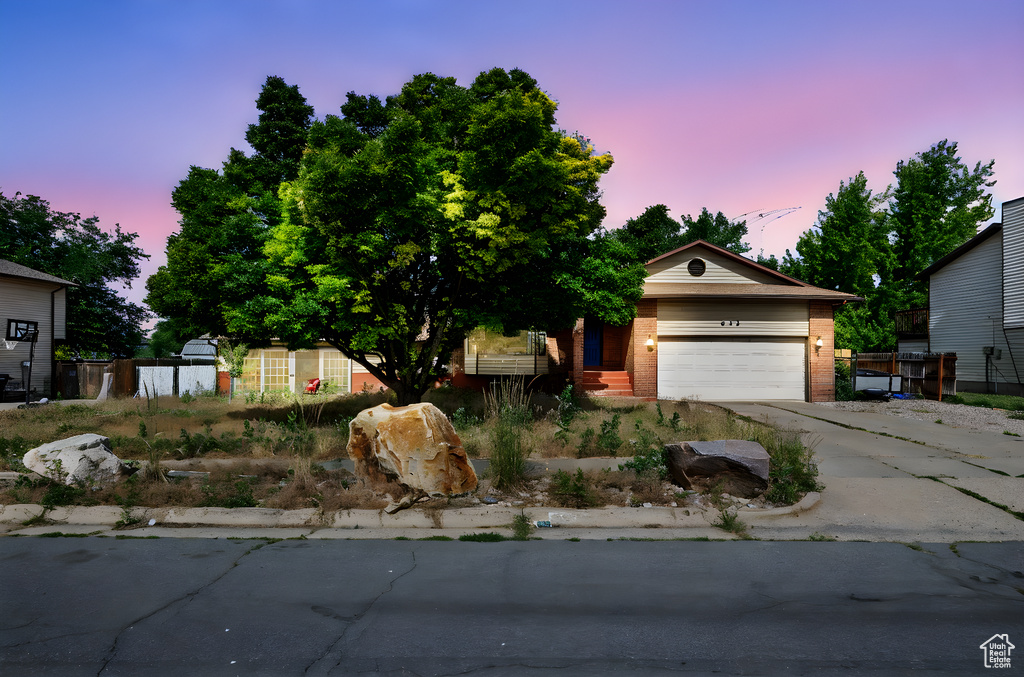 View of front of home featuring brick siding, driveway, and a garage