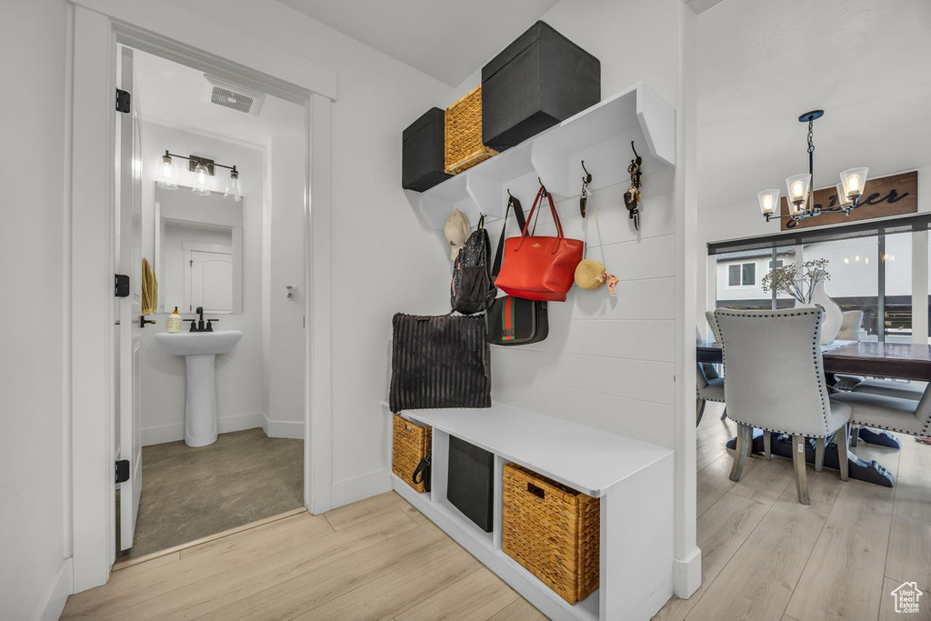Mudroom featuring a chandelier and light wood-type flooring
