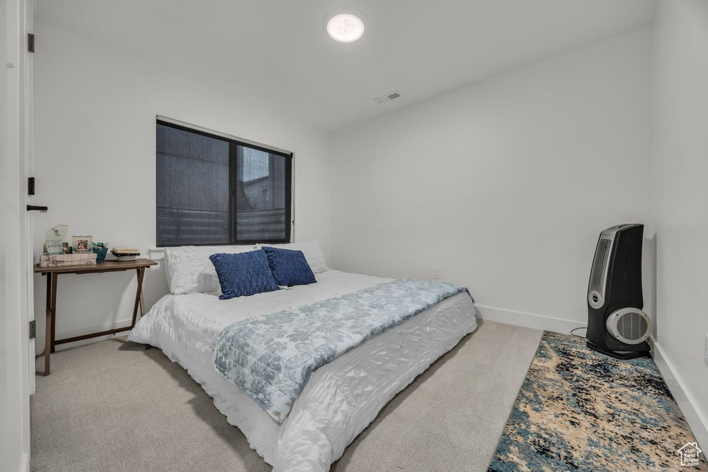 Bedroom featuring light colored carpet and baseboards