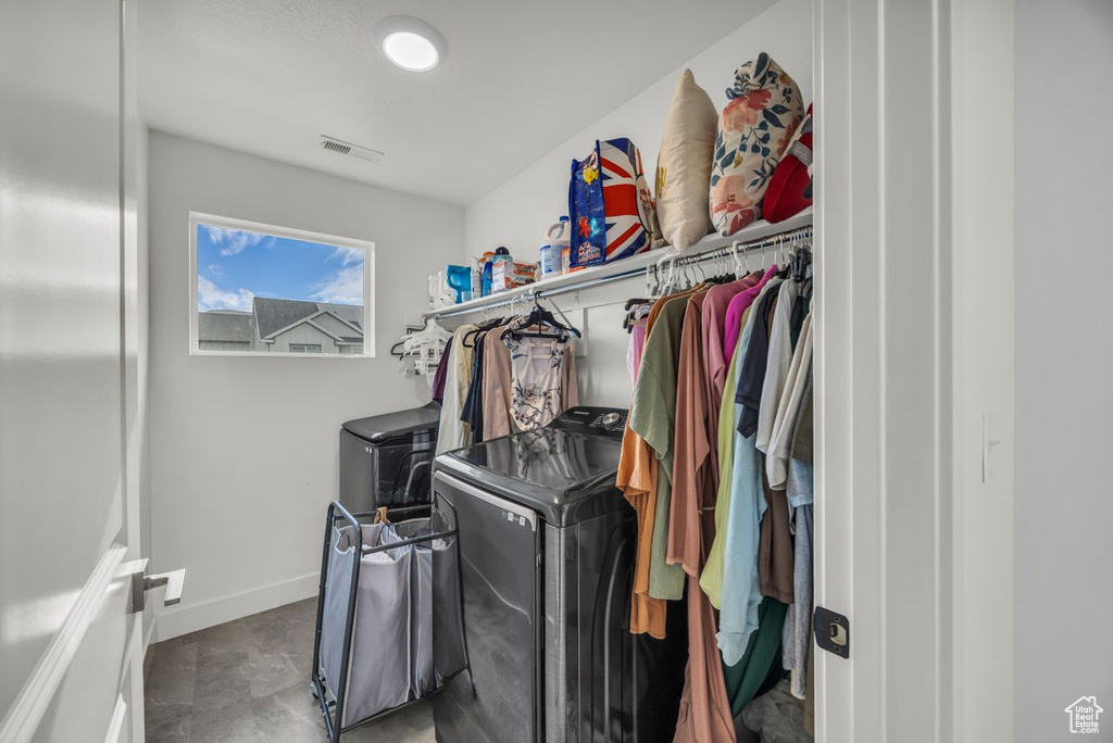 Washroom with washer and clothes dryer and baseboards