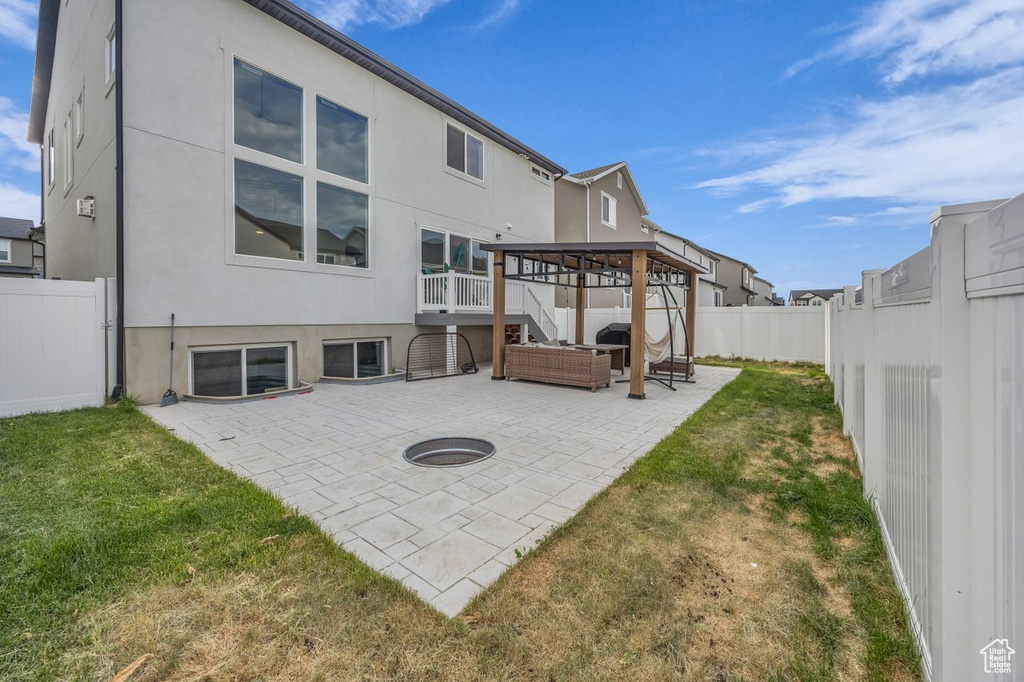Back of house featuring stucco siding, a patio, a fenced backyard, and stairway
