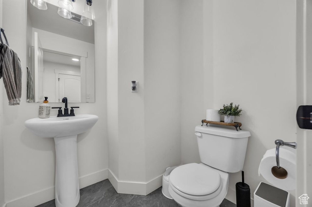 Half bathroom featuring toilet and baseboards