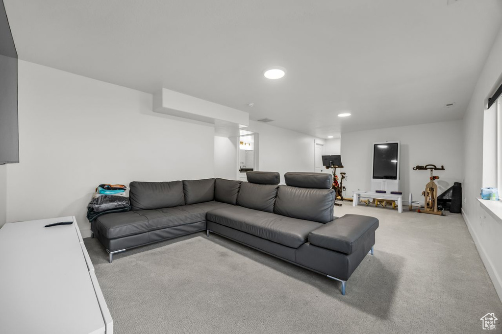 Carpeted living area with recessed lighting and baseboards