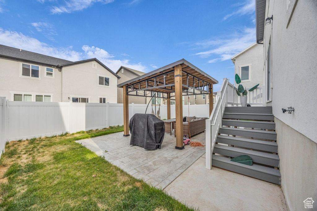Fenced backyard with a grill, an outdoor living space, a patio, and a gazebo