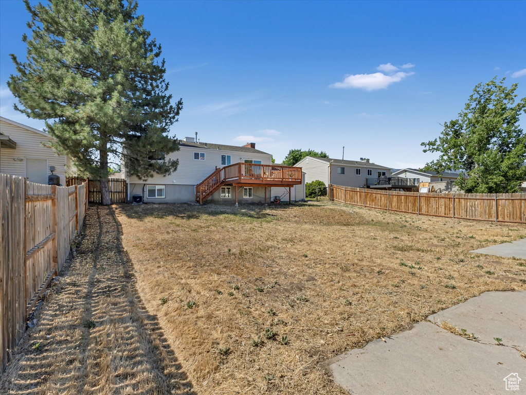 Fenced backyard with a wooden deck and stairs