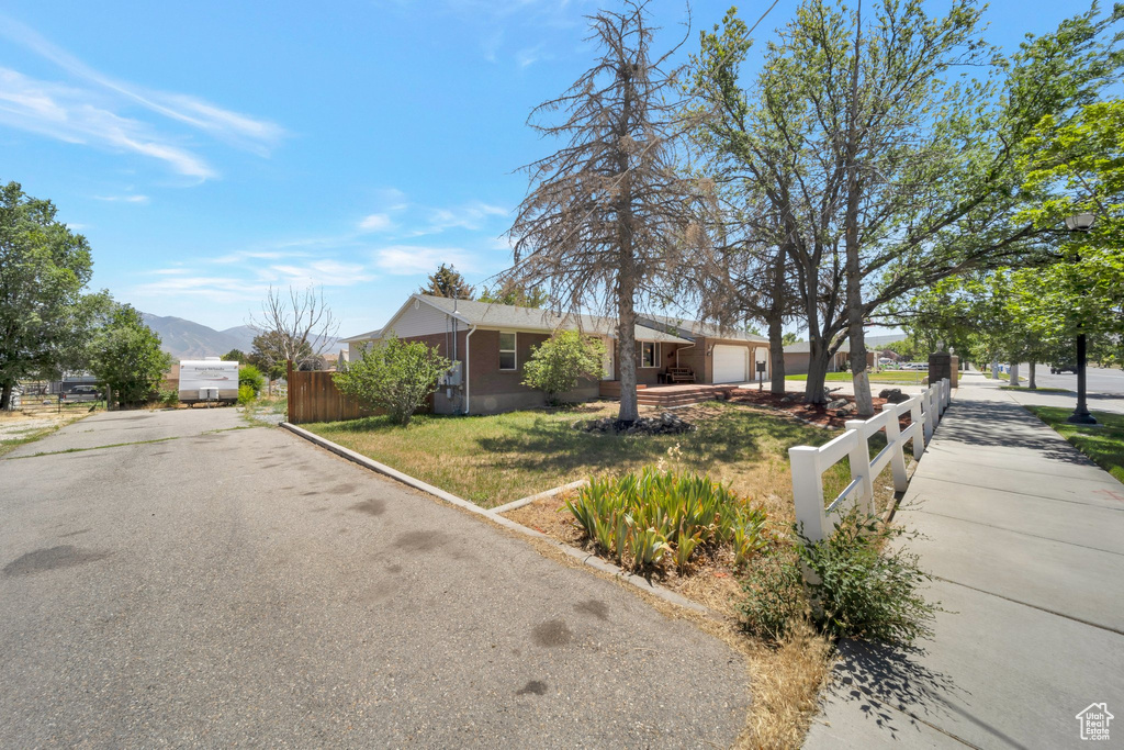 View of front of home with a garage, driveway, and a mountain view