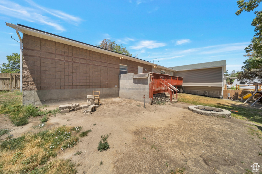 View of yard with an outdoor fire pit, a deck, and stairway
