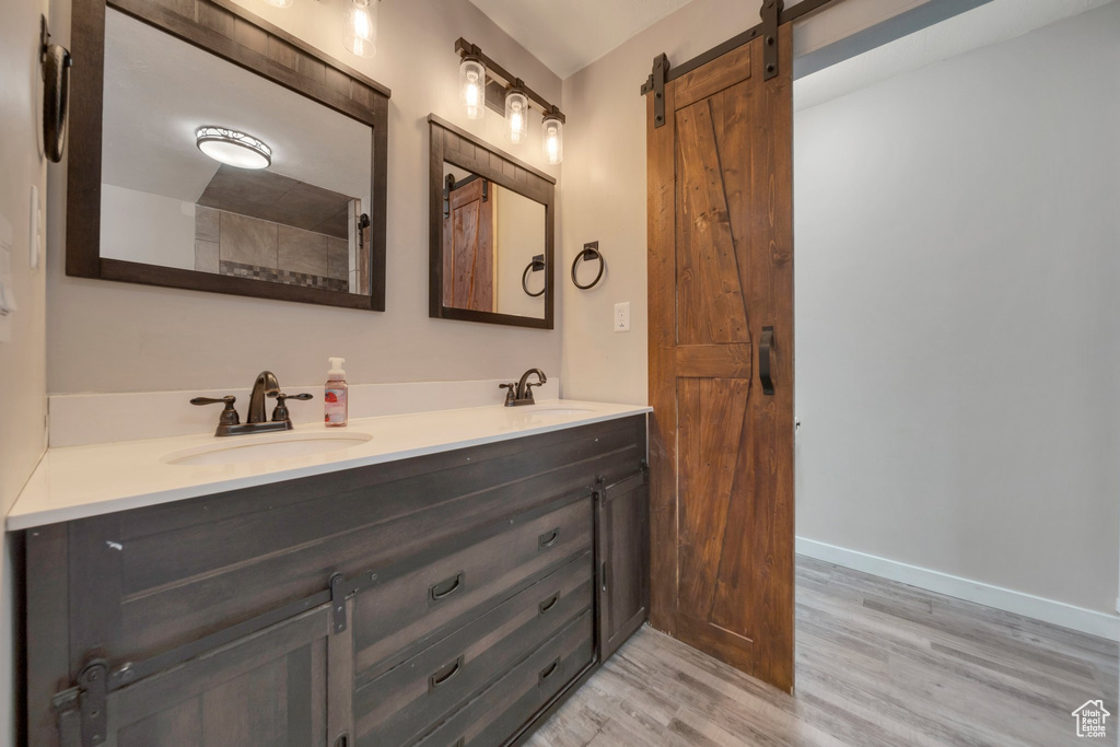 Bathroom featuring double vanity and wood finished floors