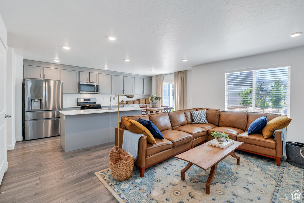 Living area featuring light wood finished floors and recessed lighting