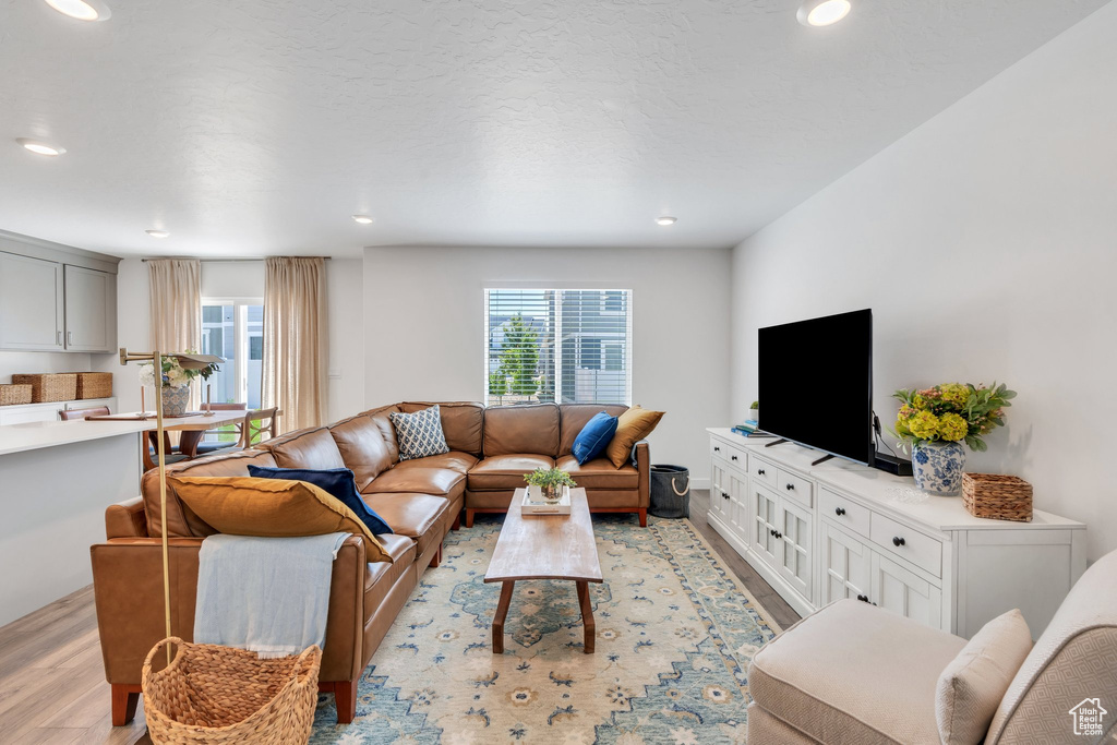 Living room with light wood-style flooring, plenty of natural light, and recessed lighting