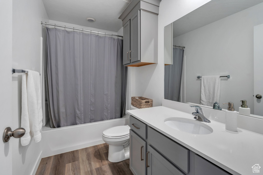 Bathroom featuring vanity, wood finished floors, and shower / bath combination with curtain